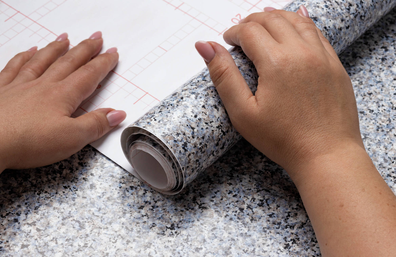 Hands carefully smoothing a roll of wallpaper during professional installation